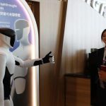 A robot gives a thumb up to a participant of the 17th Annual Meeting of the New Champions in Dalian, northeast China's Liaoning Province, on June 23, 2026. (Xinhua/Liu Lingyi)