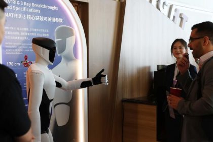 A robot gives a thumb up to a participant of the 17th Annual Meeting of the New Champions in Dalian, northeast China's Liaoning Province, on June 23, 2026. (Xinhua/Liu Lingyi)