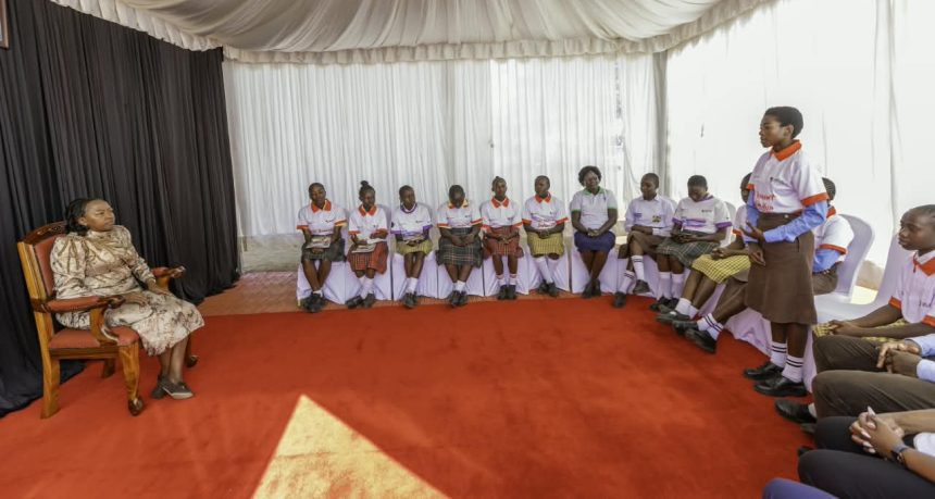 First Lady Rachel Ruto (left) listening to girls